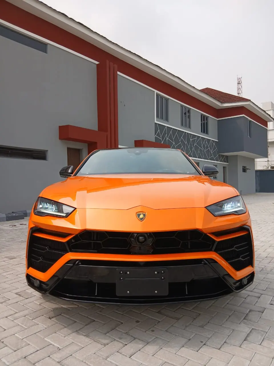 Orange Lamborghini Urus front view, available for hire in Lagos